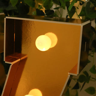 Gold marquee number seven with lights, reflecting shiny surfaces.