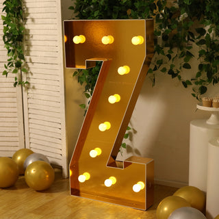 Gold marquee letter "Z" with lights, styled in a festive setting.