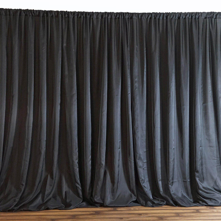 Black satin stage curtains draped elegantly in a theater setting.