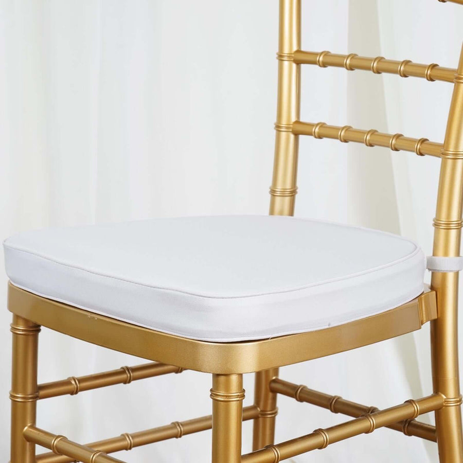 Gold chiavari chair with white cushion on plain background