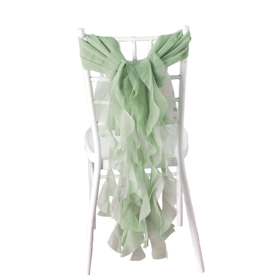Green ruffled chiffon chair sash draped on a white chair.