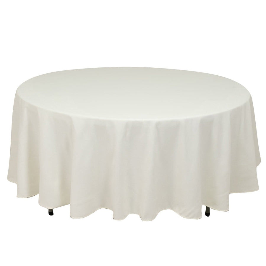 Round white table with a draped cloth.