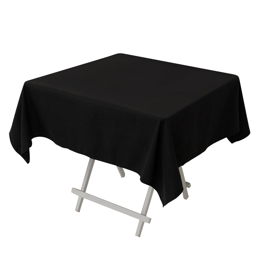 Black tablecloth draped over a folding table