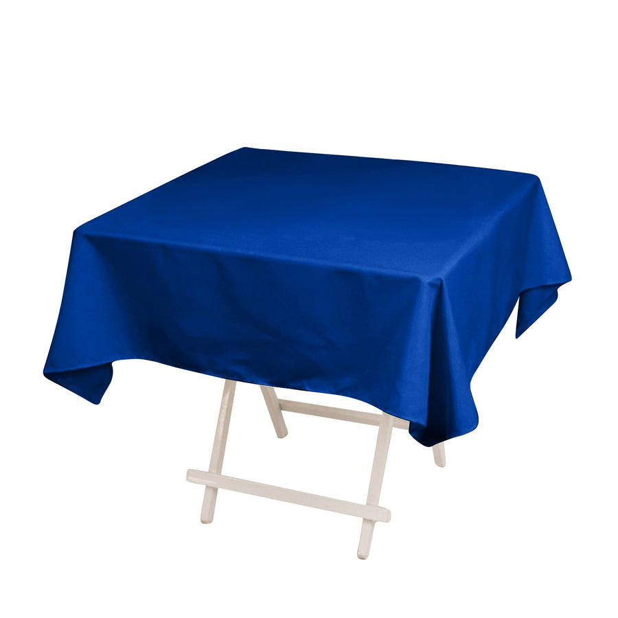 Blue tablecloth on a folding table against a plain backdrop