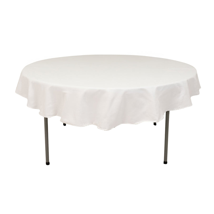 Round table with a white tablecloth on a plain backdrop