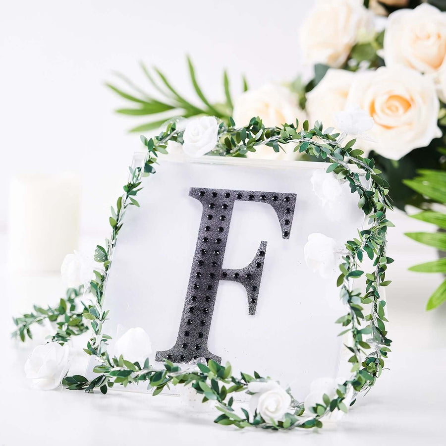 Decorative letter "F" with floral accents in a styled arrangement.