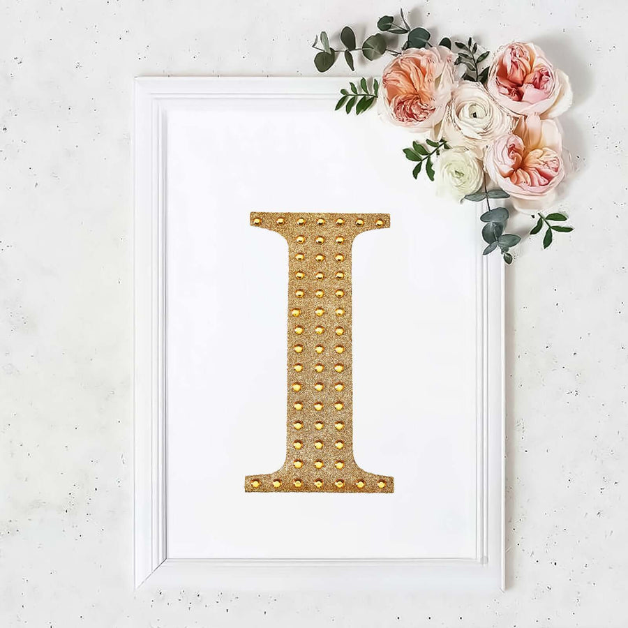 Gold embellished letter "I" wall art with floral arrangement