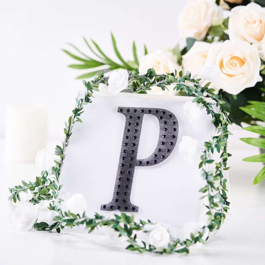 Decorative letter "P" with floral accents and greenery.