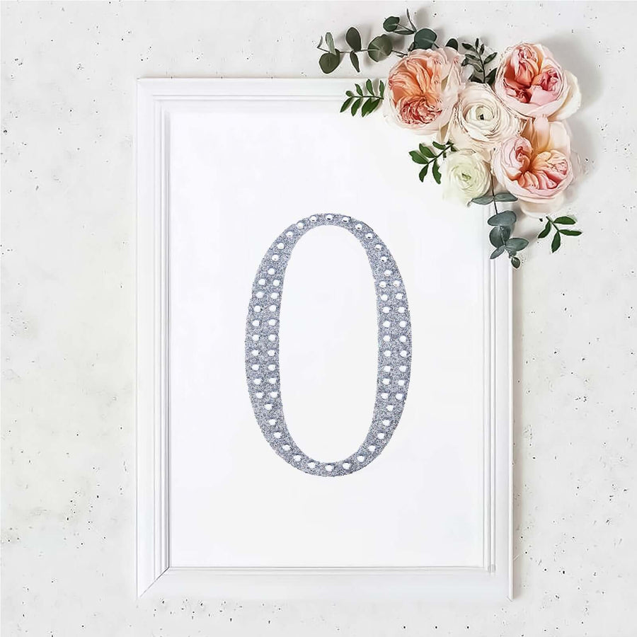 Framed number "0" design with floral accents on a white background.