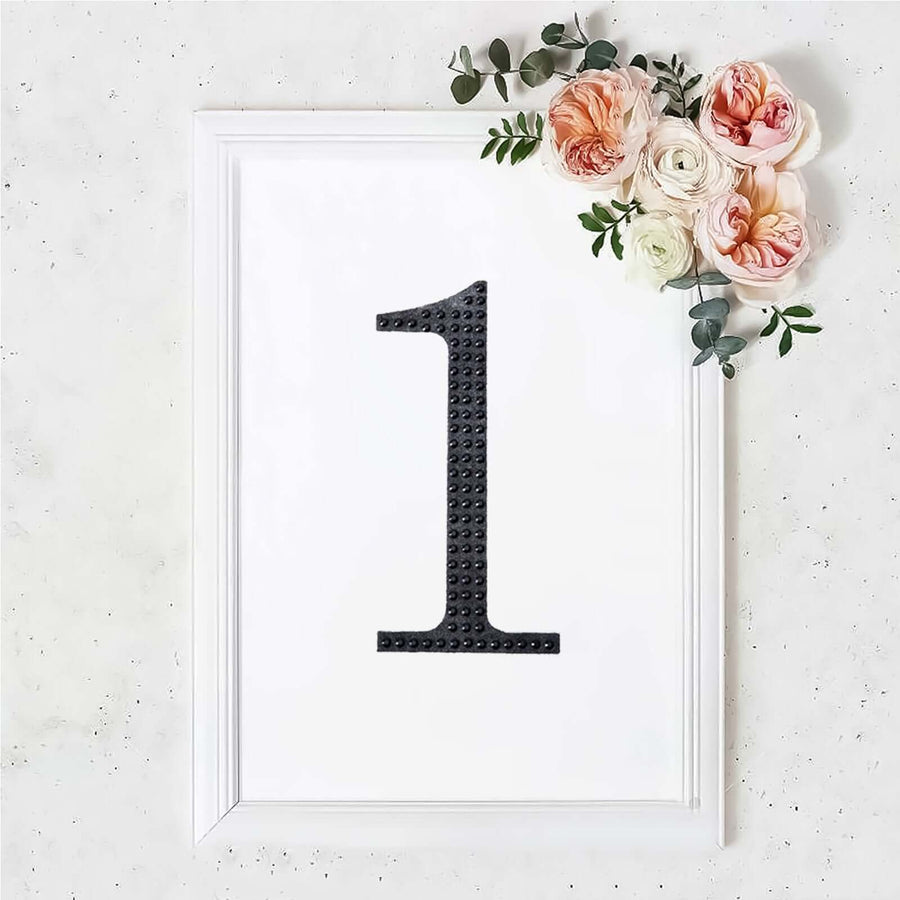 Black number one in a white frame adorned with flowers
