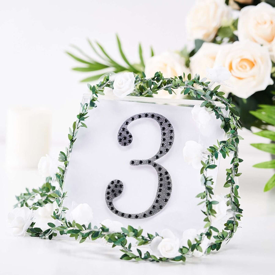 Decorative table number 3 with greenery and white flowers