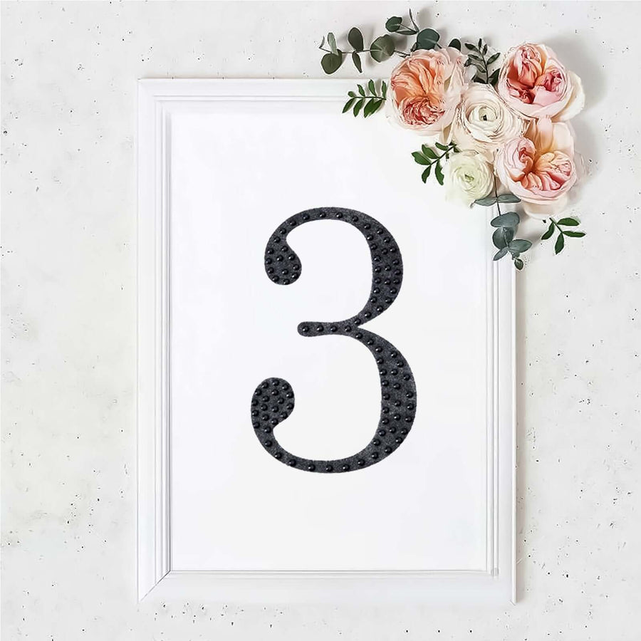 Black number three in a framed design with flowers.