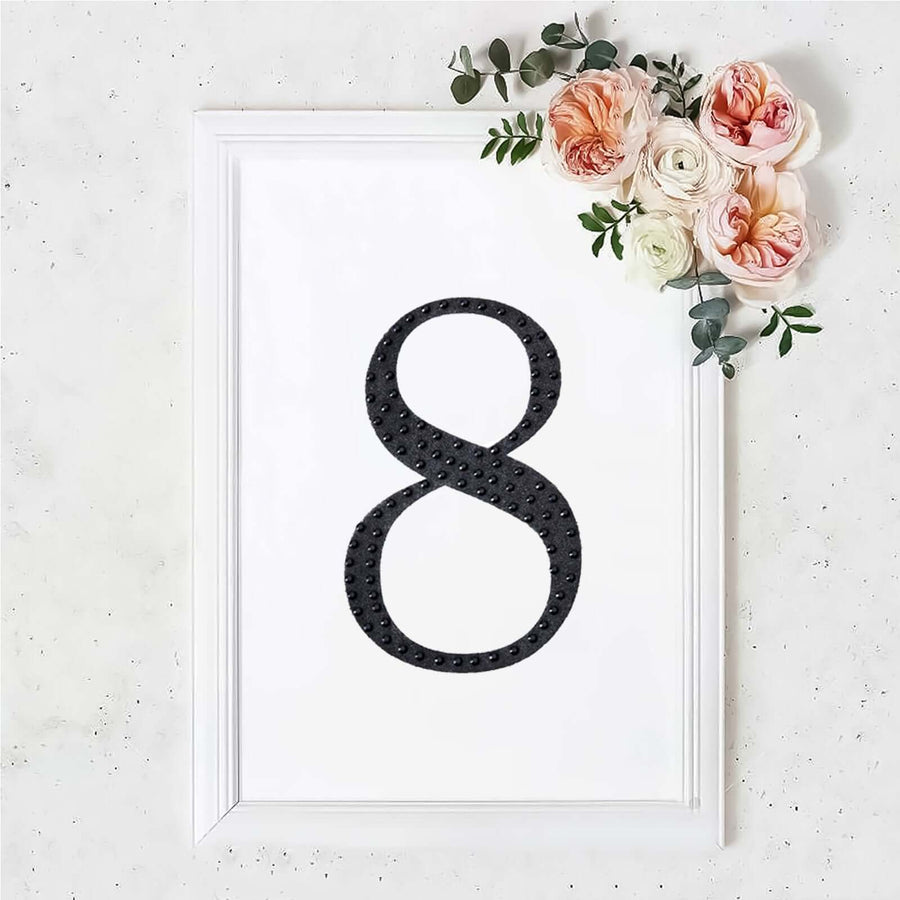 Black number 8 in a white frame with floral accents on a light background.
