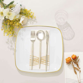 Elegant white plate with silver cutlery and decorative napkin on a clean surface.