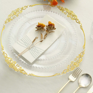 Elegant clear plate with gold trim, napkin, and decorative flowers.