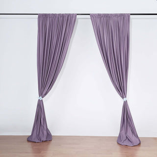 Purple curtain panels draped on a rod in a studio setting.