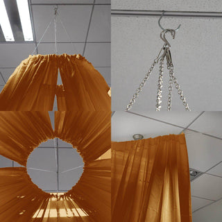 Orange curtain hanging with metal hooks and chains in a ceiling setup.