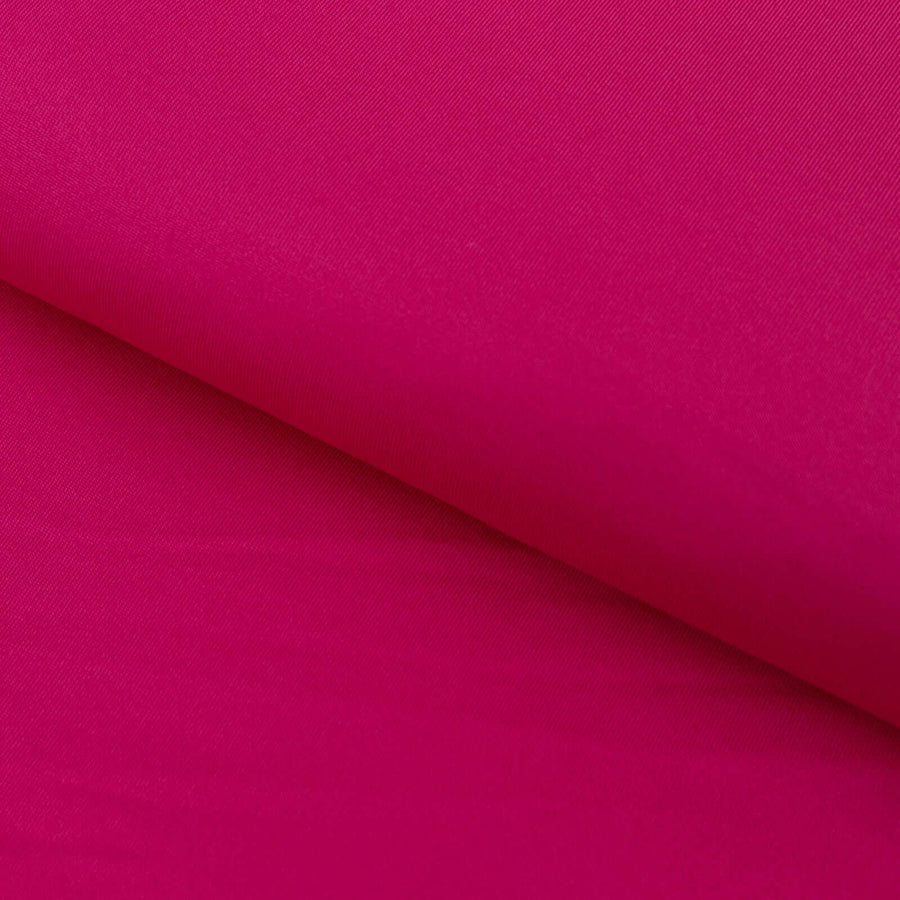 Bright fuchsia fabric roll showcasing smooth texture and rich color.