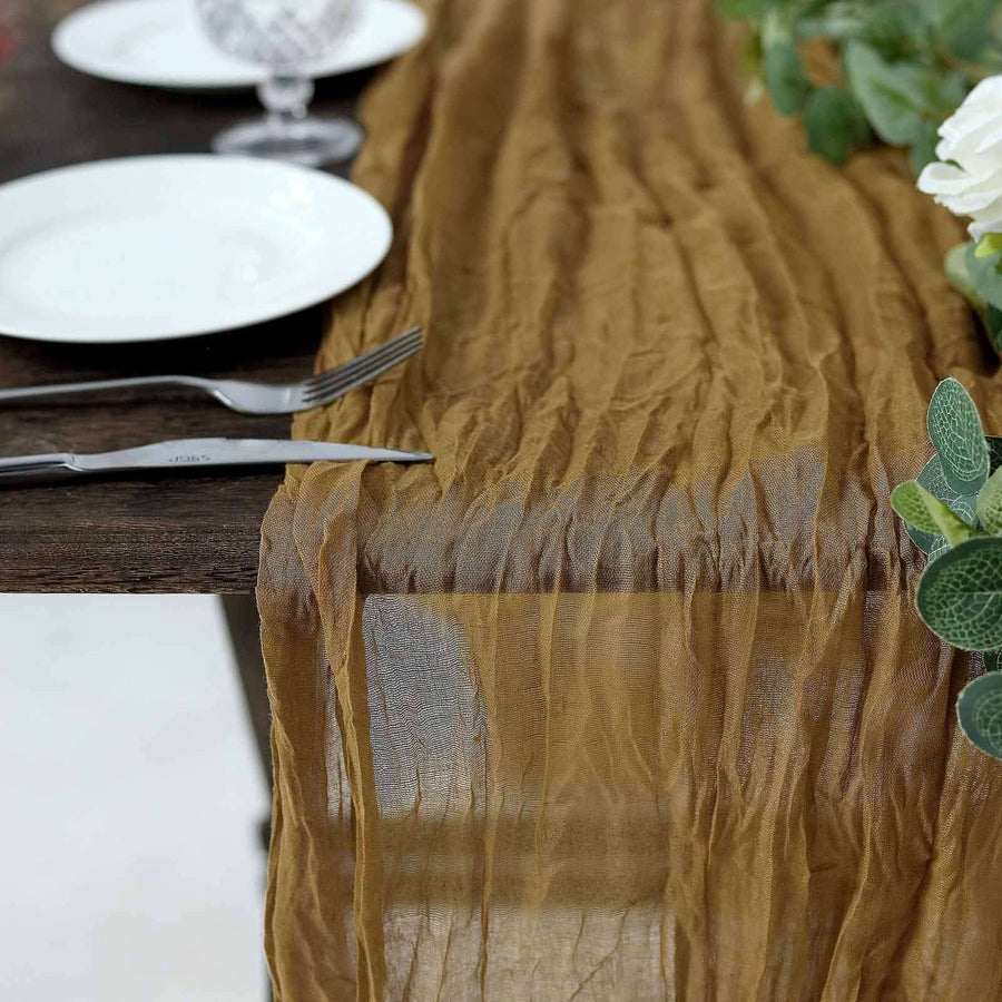 Wrinkled brown table runner draped over a rustic wooden table.