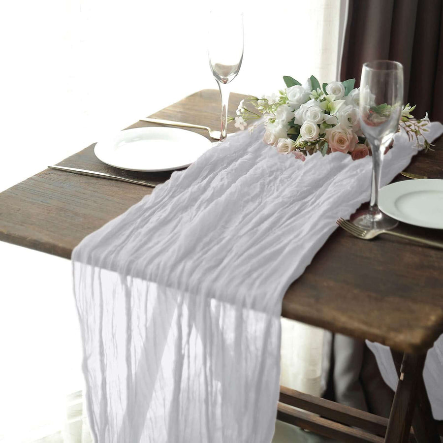 White textured table runner on a rustic wooden table with elegant dinnerware.