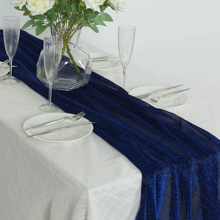 Navy blue glitter table runner with elegant dinnerware set on a white table