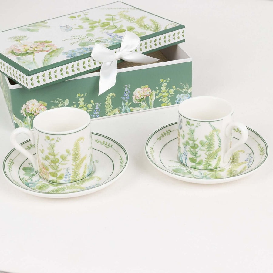 Floral patterned teacups with saucers and a decorative gift box