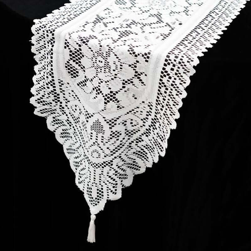 White lace table runner with floral pattern and tassel detail. #whtbkgd