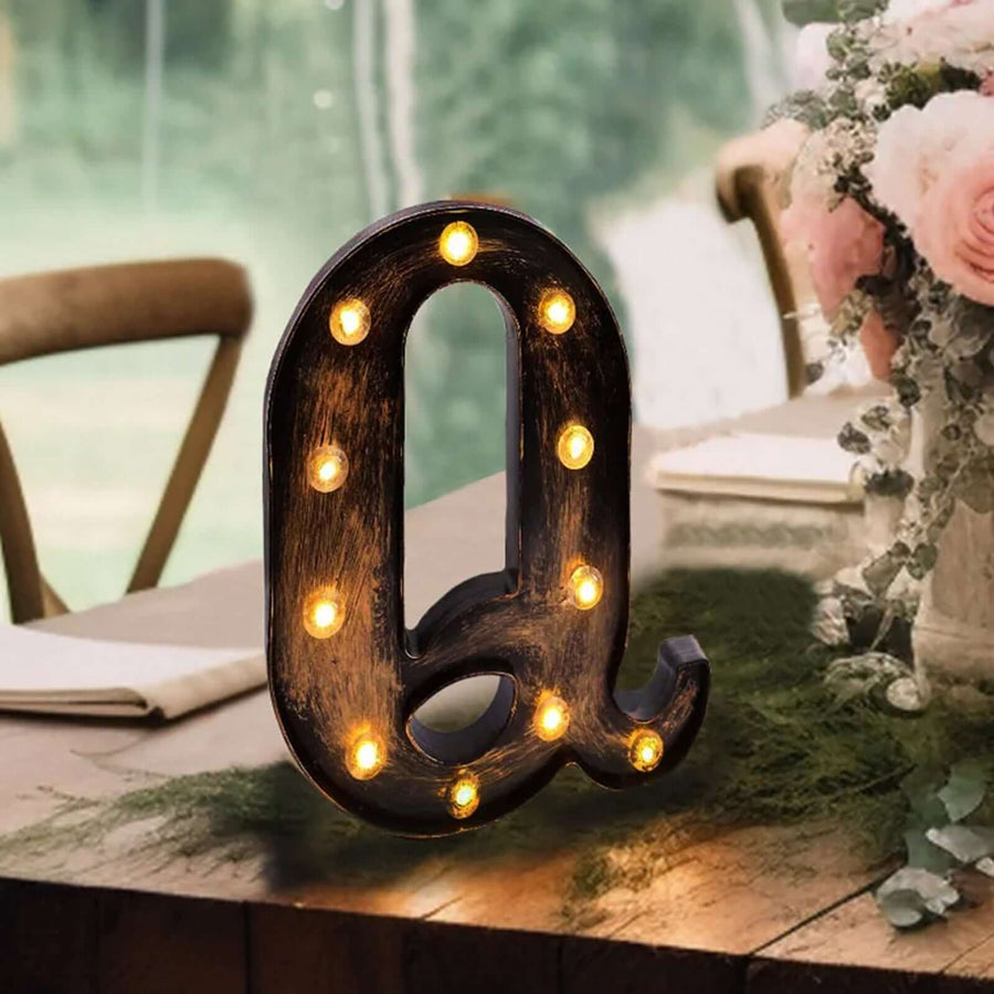 Decorative marquee letter "Q" with lights, styled for event decor.