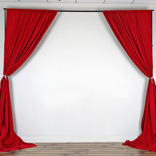 Red stage curtains draped elegantly against a plain backdrop.
