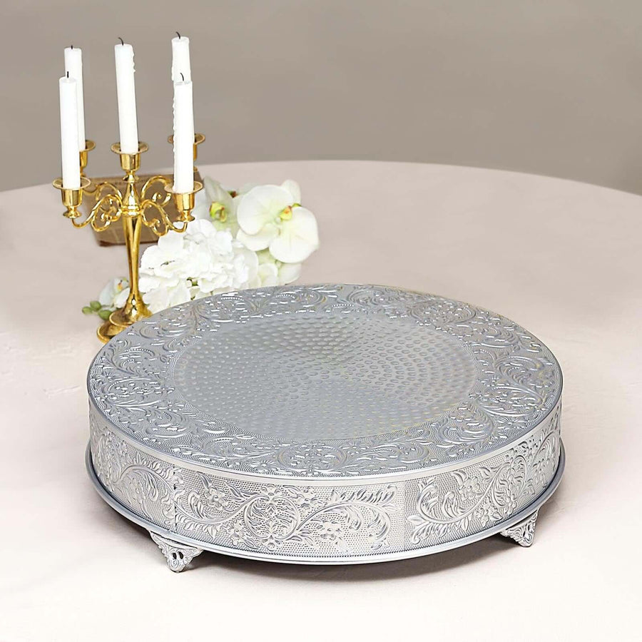 Silver decorative cake stand with intricate design and ornate edges.