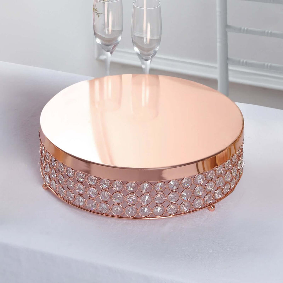 Rose gold cake stand with crystal accents on a white table.