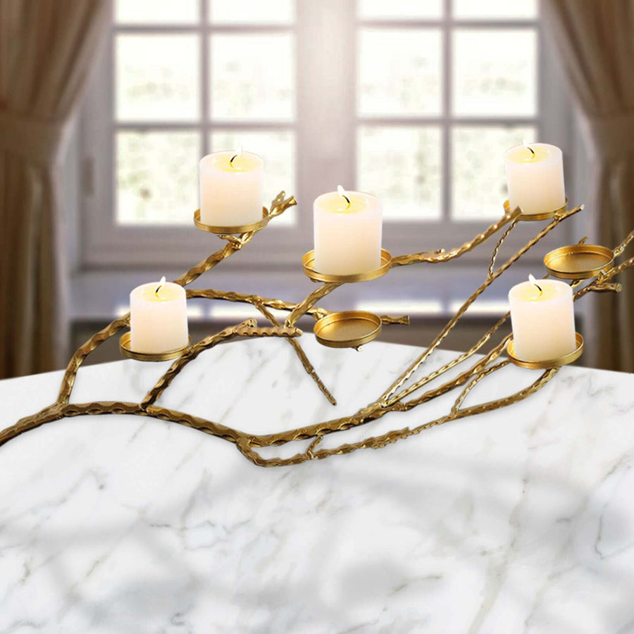 Elegant gold candle holder with five candles on a marble surface.