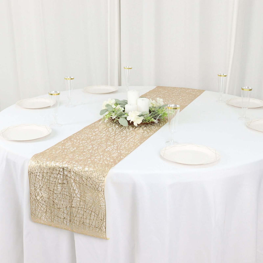 Elegant gold table runner on a white table with candles and floral decor.