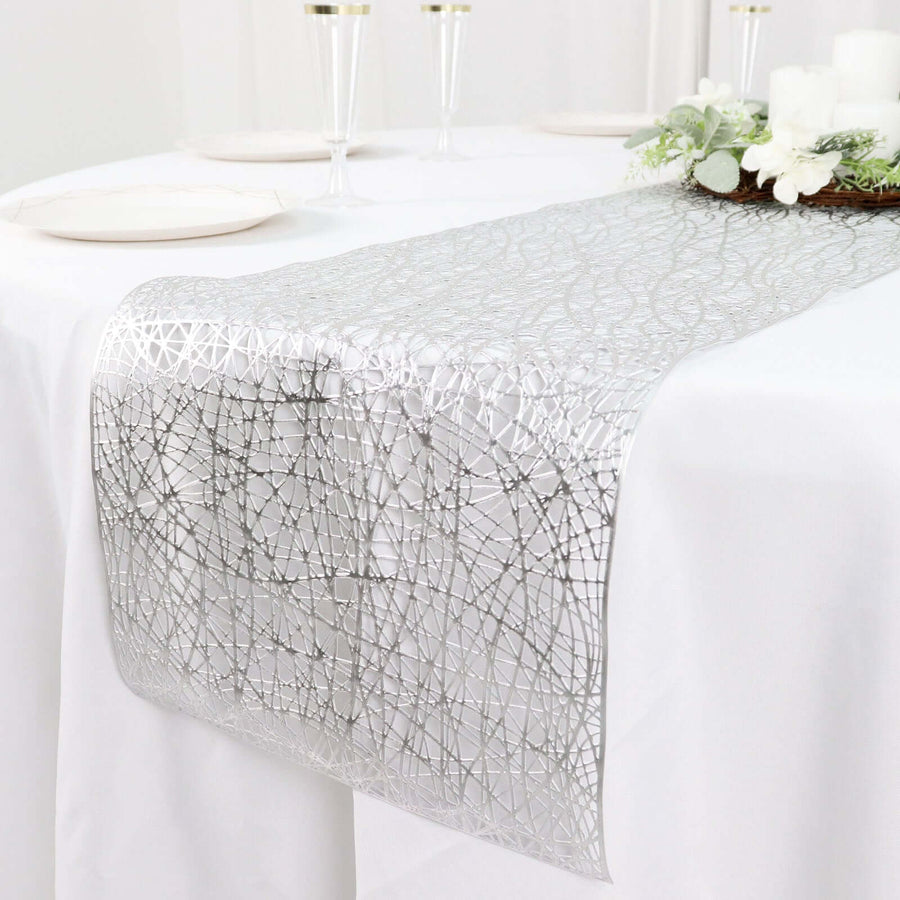 Silver lace table runner on a white table setting for elegant decor.