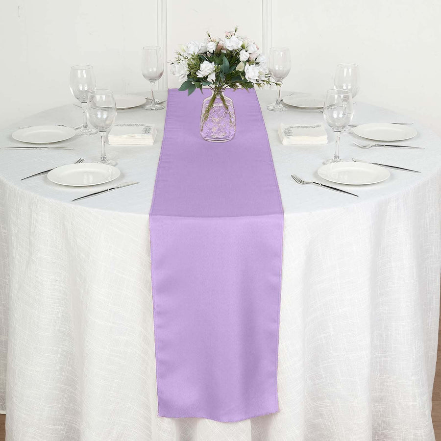Purple table runner on a white table with plates and glasses arranged neatly.