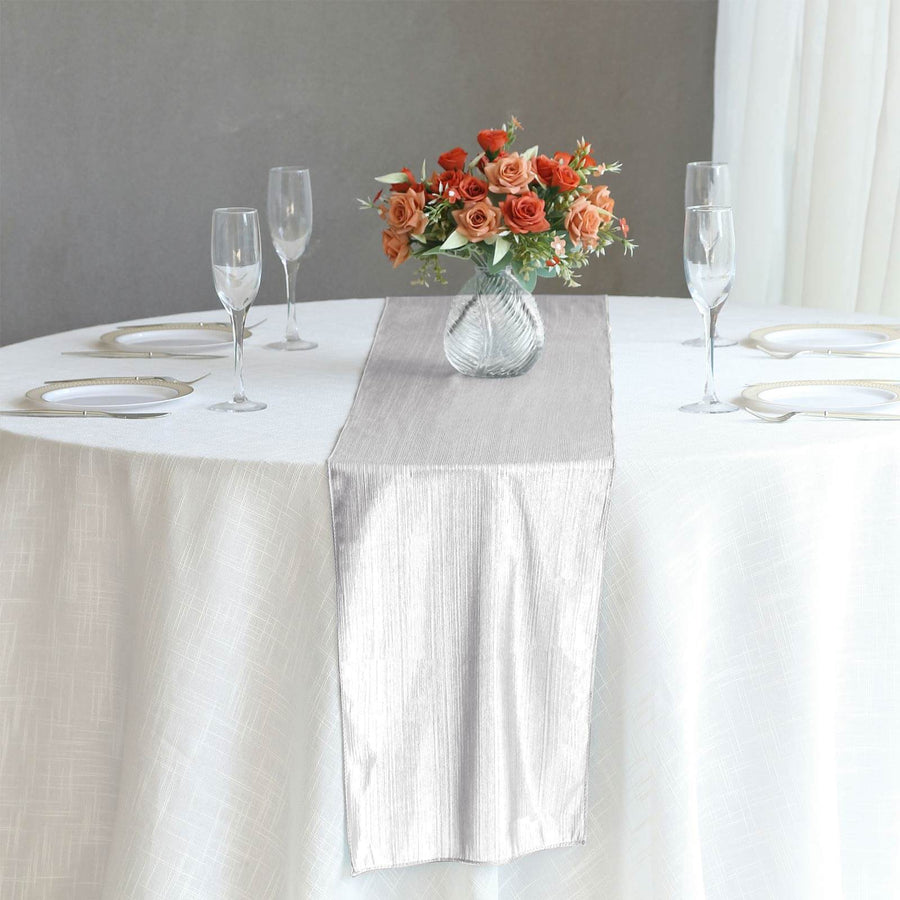 Elegant silver table runner on a beautifully set dining table with flowers.