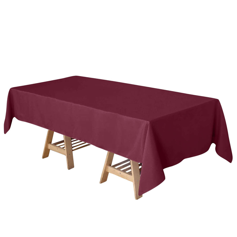 Burgundy tablecloth on a wooden table with a folding design