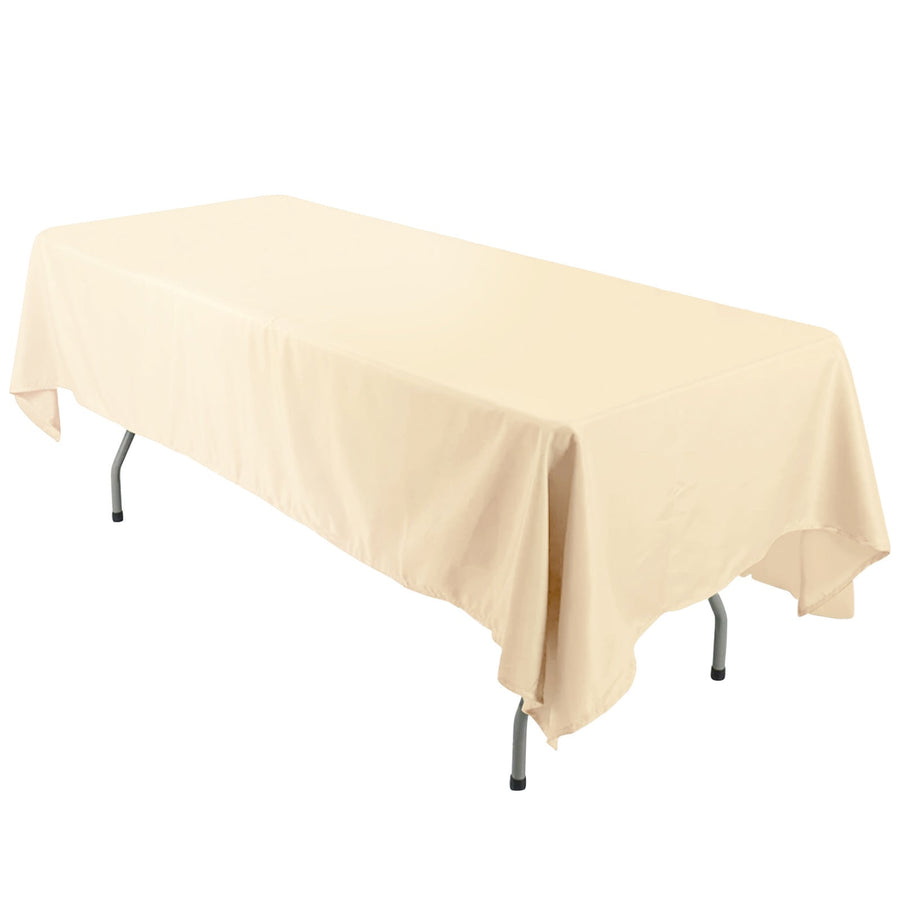 Beige tablecloth draped over a folding table on a plain backdrop.