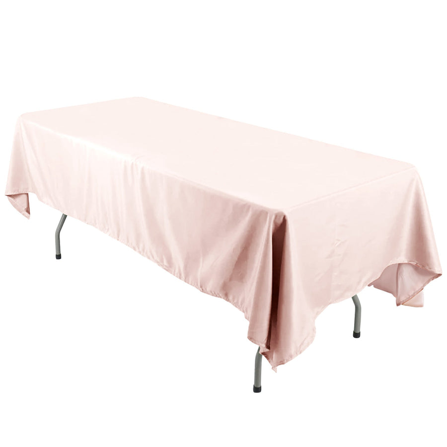 Pink tablecloth draped over a folding table on a white backdrop.