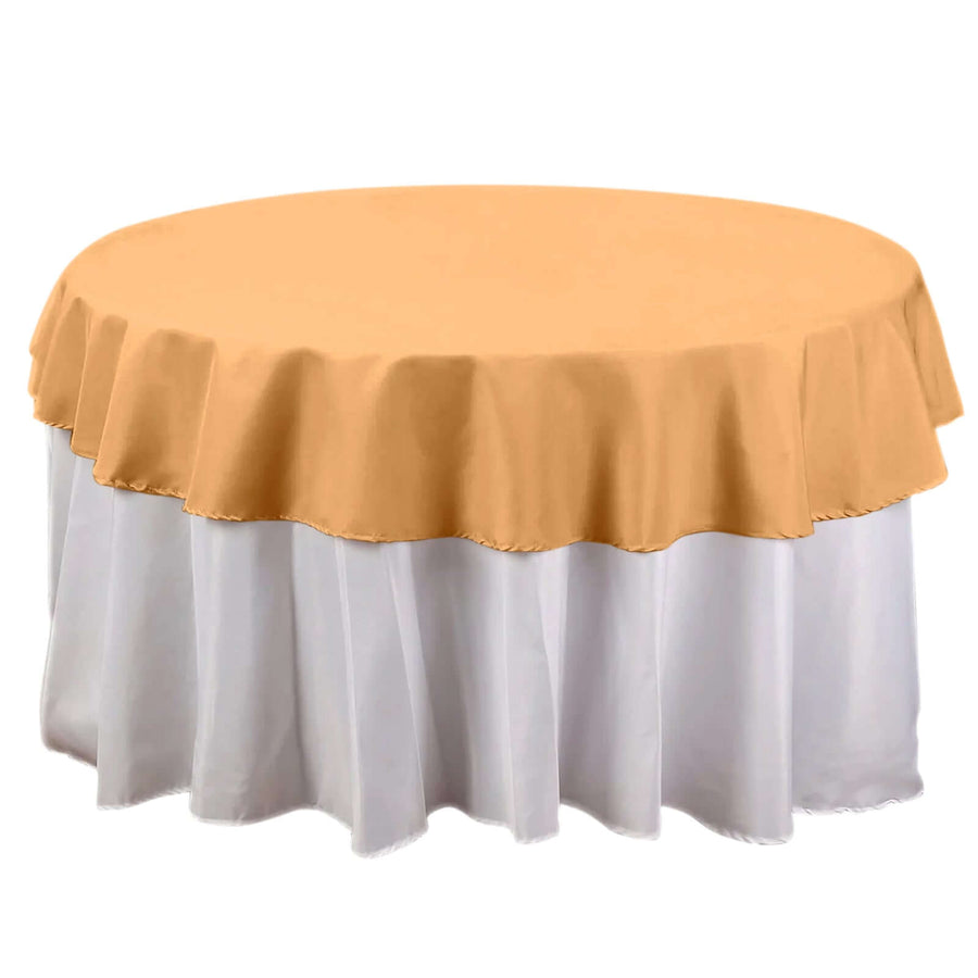 Round table with a gold tablecloth and white skirt