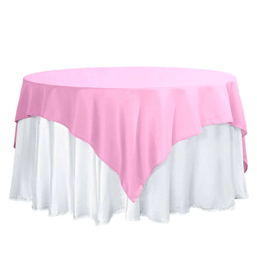 Pink tablecloth on a round table with a white skirt.