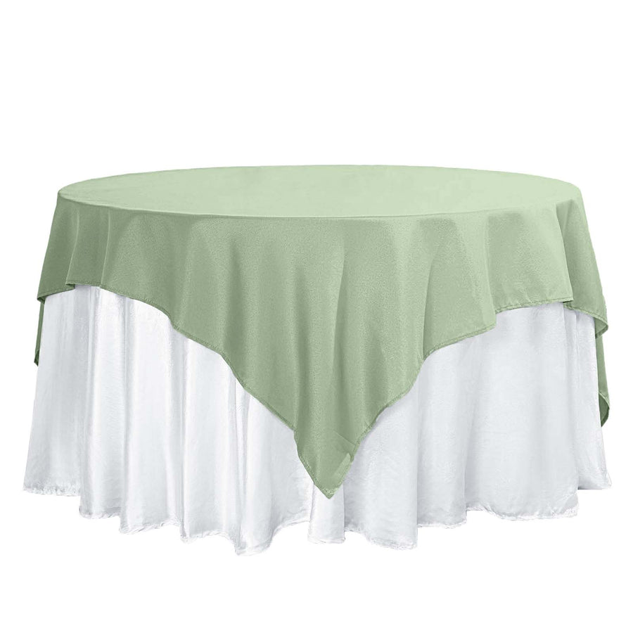 Green round tablecloth draped over a white tablecloth