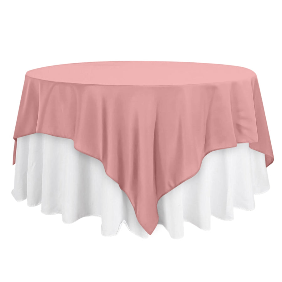 Round table with a pink tablecloth and white skirt.