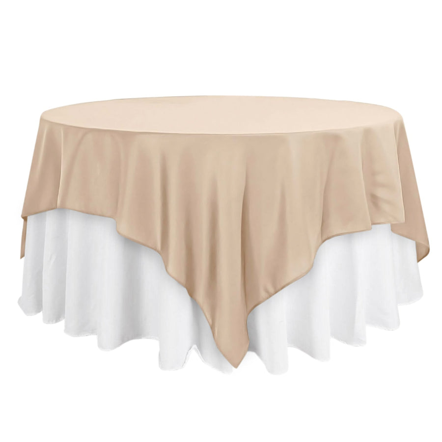 Round beige tablecloth draped over a white table