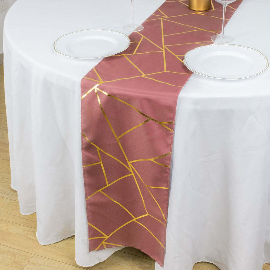 Rose gold geometric table runner on a white tablecloth.