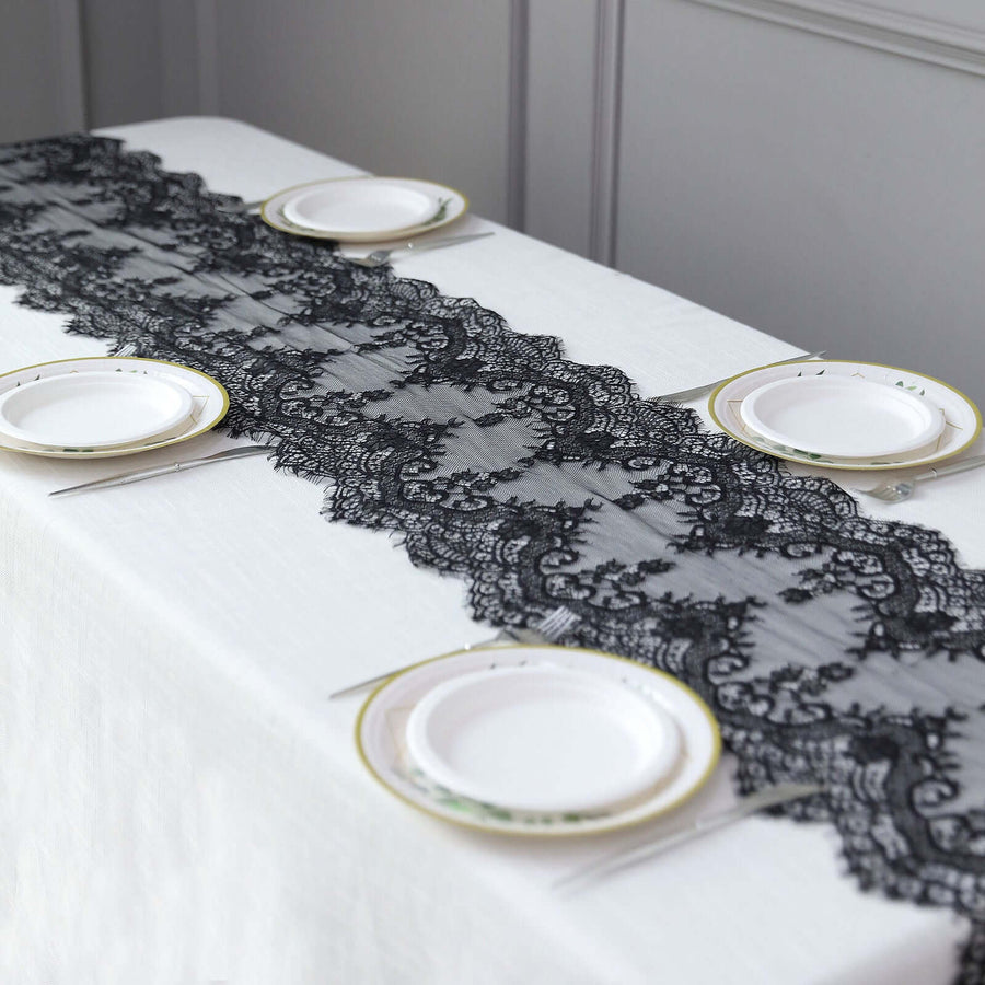 Black lace table runner on a white table with plates arranged for dining.