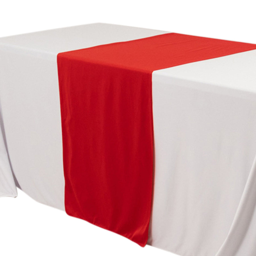 Red table runner draped over a white table.
