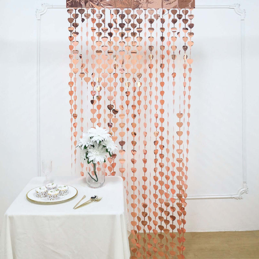 Rose gold heart garland backdrop with table setting for events and celebrations.