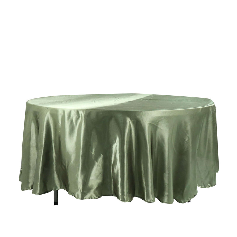 Round olive green tablecloth on a plain backdrop