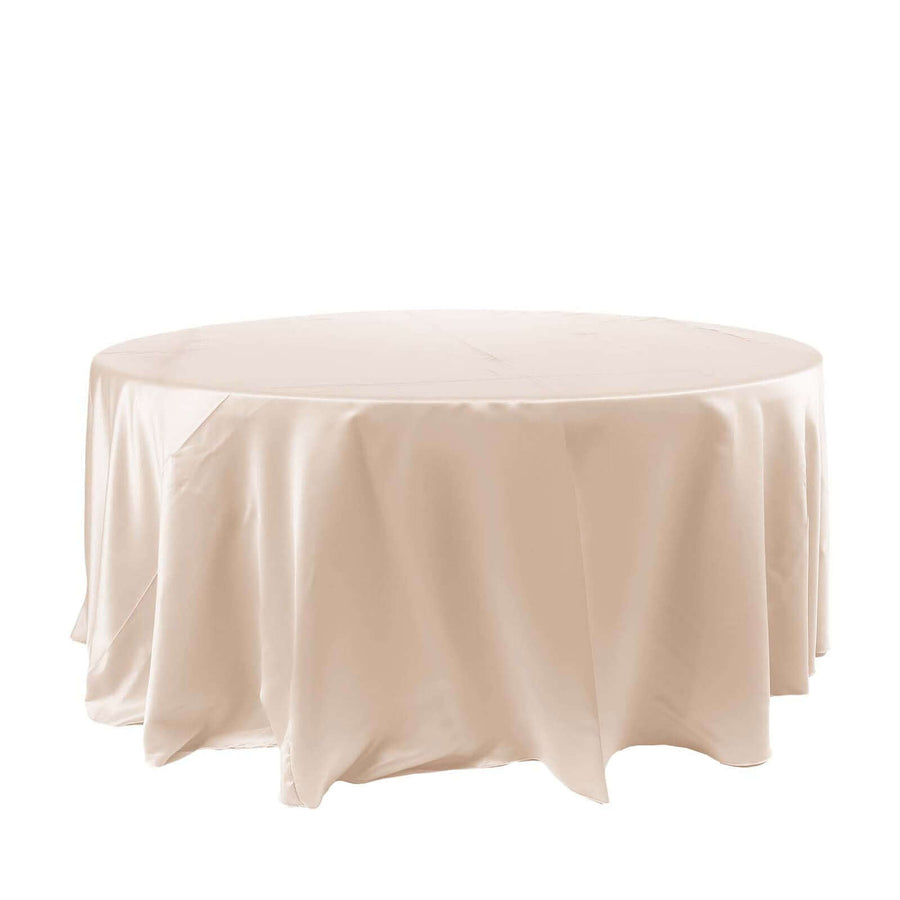 Round beige tablecloth on a plain backdrop.